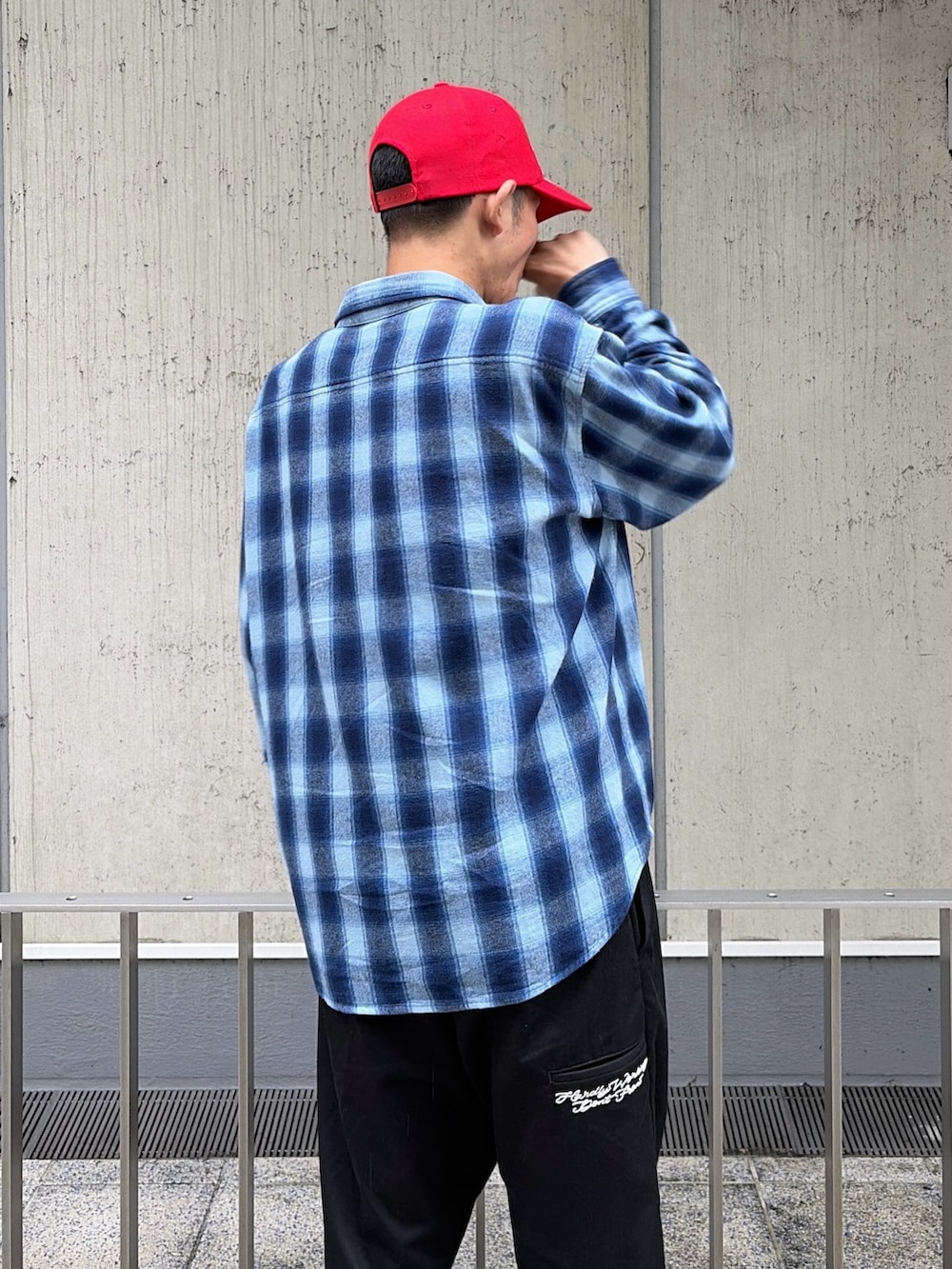 ブルー系のシャツ/ブラウス、ブラック系のその他パンツ、レッド系のキャップを着用したメンズの秋コーディネートの8枚目の写真