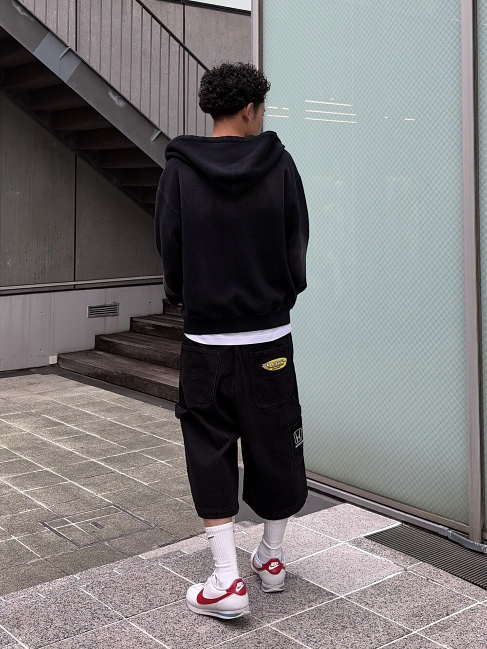 ホワイト系のTシャツ/カットソー、ブラック系のデニムパンツ、ブラック系のパーカーを着用したメンズの春コーディネートの7枚目の写真