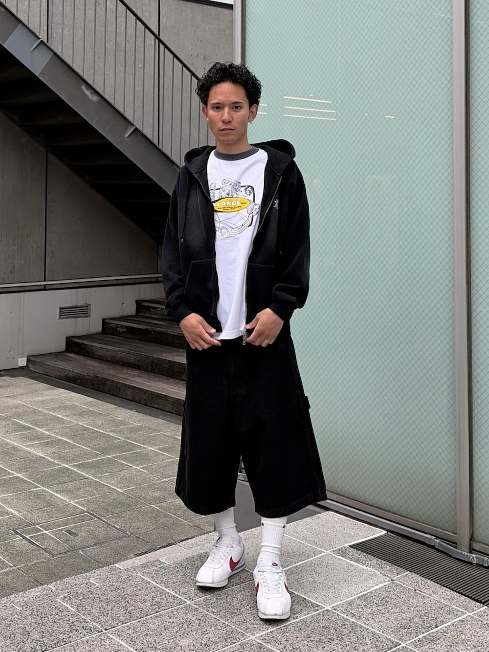 ホワイト系のTシャツ/カットソー、ブラック系のデニムパンツ、ブラック系のパーカーを着用したメンズの春コーディネートの4枚目の写真