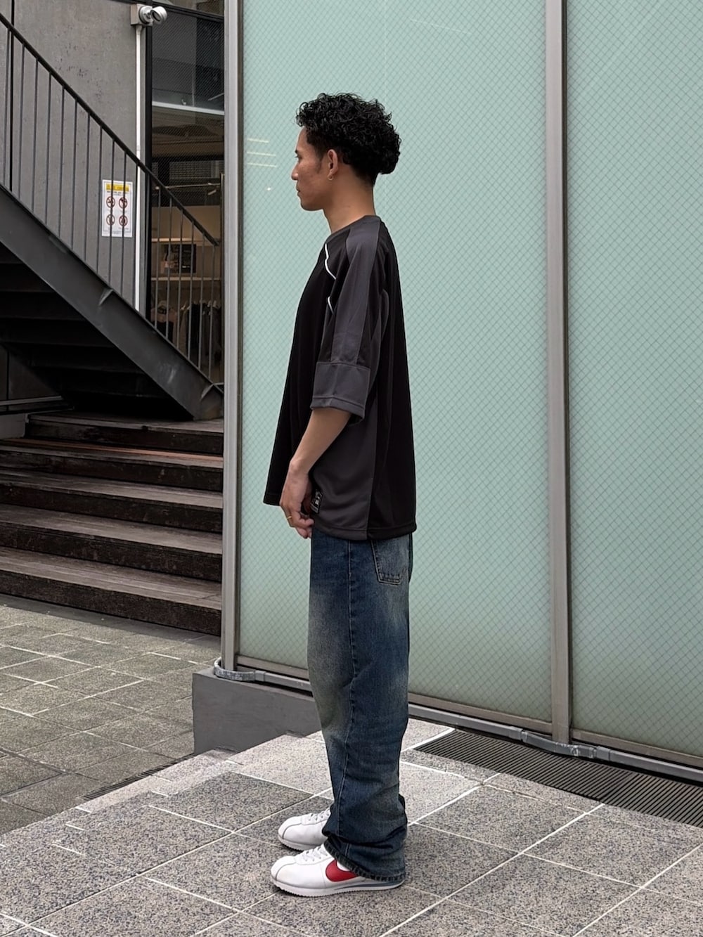 ブルー系のデニムパンツ、ブラック系のシャツ/ブラウスを着用したメンズの春コーディネートの2枚目の写真