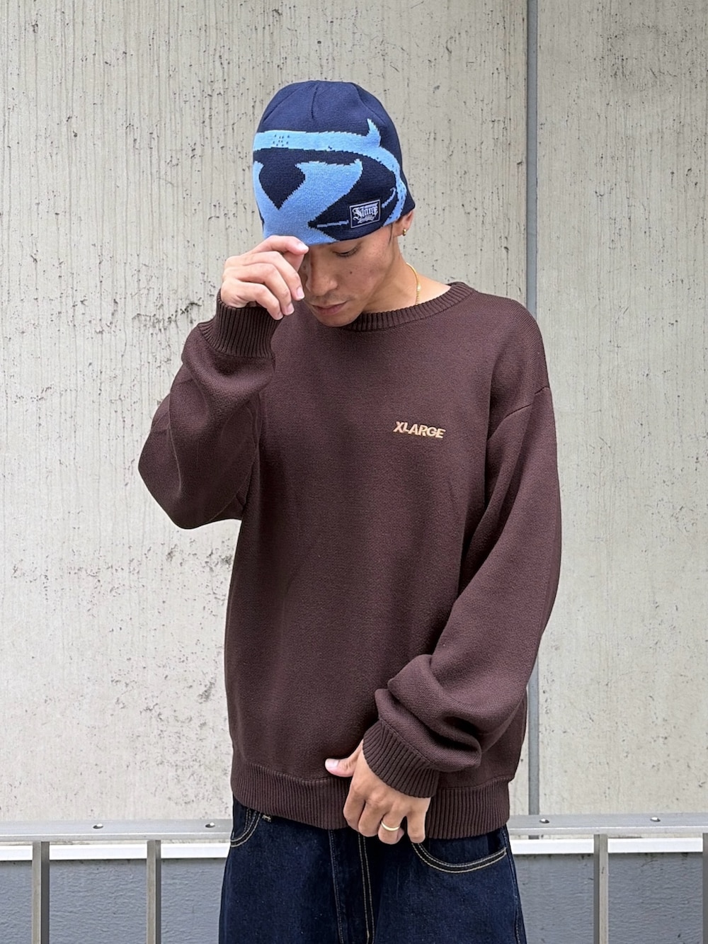 ブラウン系のニット/セーター、ブルー系のデニムパンツ、ブルー系のキャップを着用したメンズの秋コーディネートの8枚目の写真