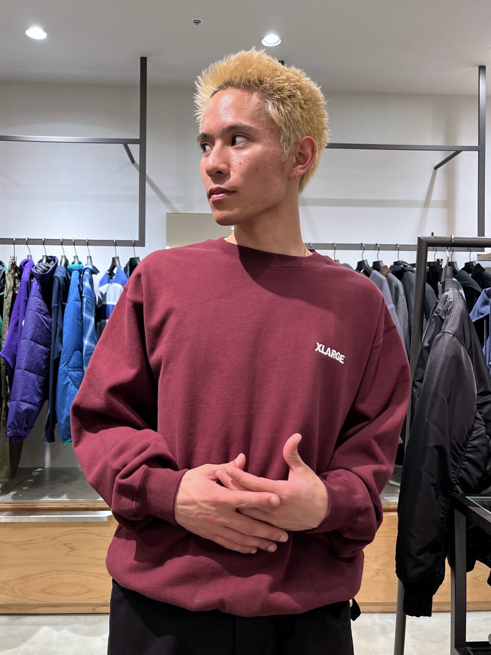 レッド系のスウェット、ブラック系のその他パンツ、ブラック系のダウンベストを着用したメンズの秋コーディネートの5枚目の写真