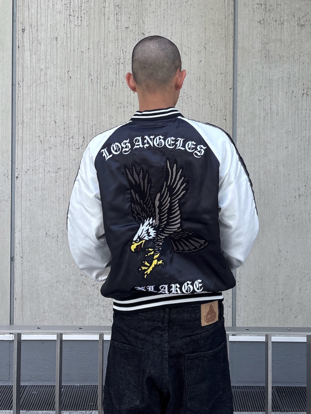 ブラック系のスカジャン、ブラック系のデニムパンツを着用したメンズの秋コーディネートの8枚目の写真