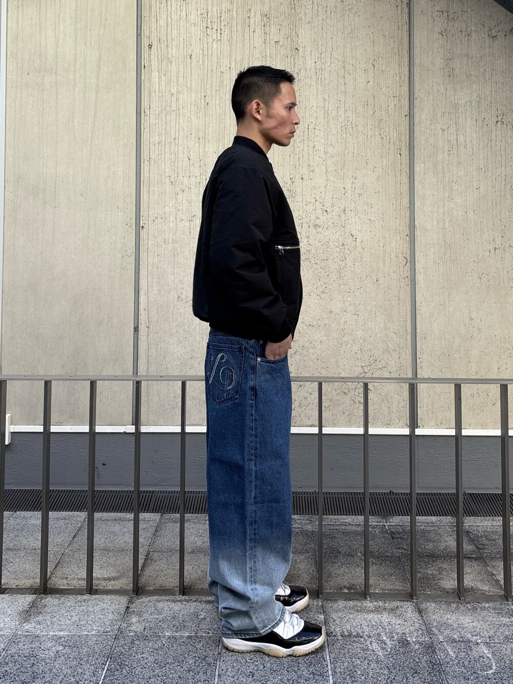 ブラック系のブルゾン、ブルー系のデニムパンツを着用したメンズの冬コーディネートの3枚目の写真