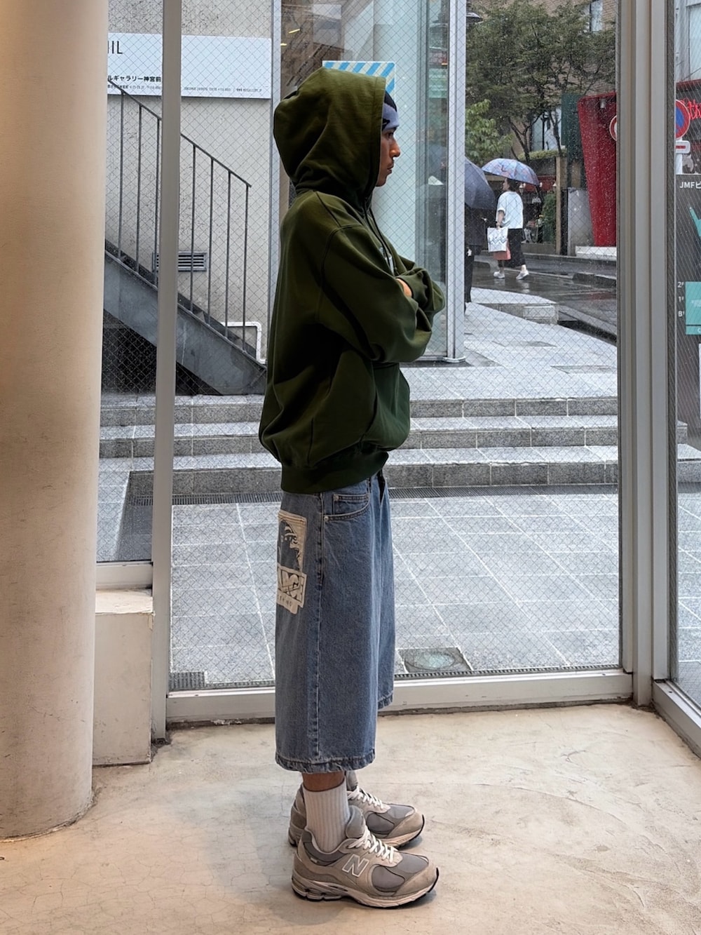 グリーン系のパーカー、グリーン系のデニムパンツ、ブルー系のキャップを着用したメンズの秋コーディネートの3枚目の写真