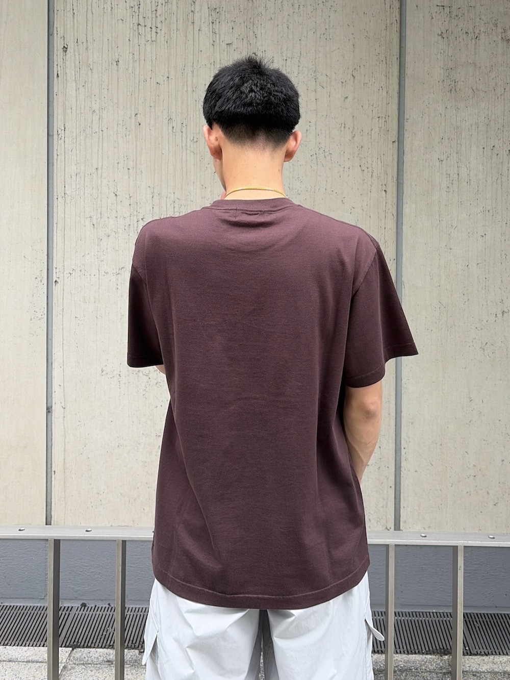 ブラウン系のTシャツ/カットソー、ホワイト系のカーゴパンツを着用したメンズの夏コーディネートの6枚目の写真
