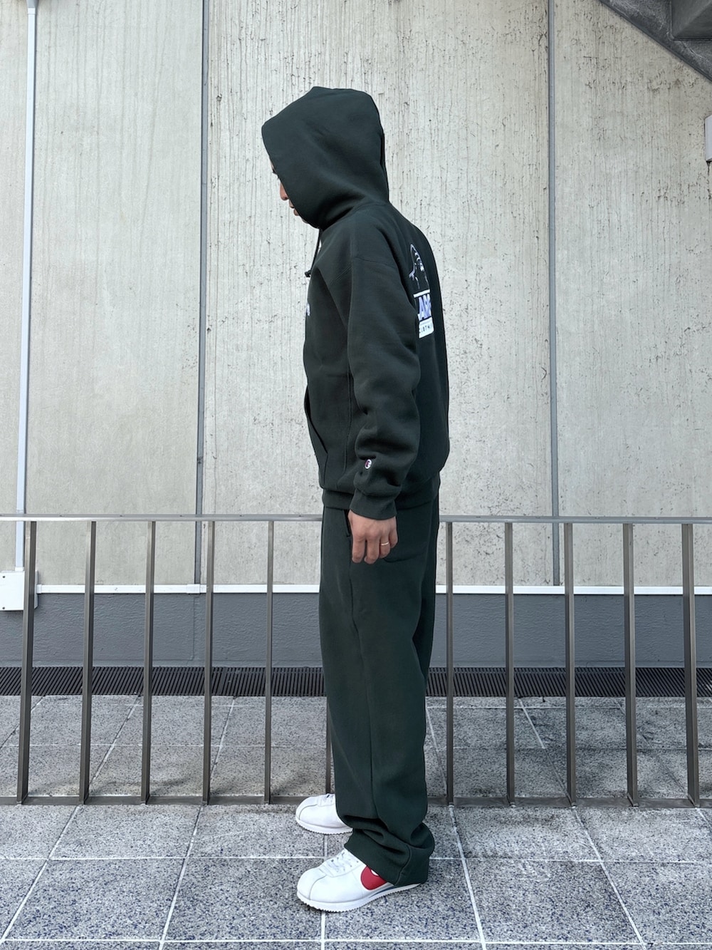 グリーン系のパーカー、グリーン系のスウェットパンツ、ブラック系のキャップを着用したメンズの秋コーディネートの4枚目の写真