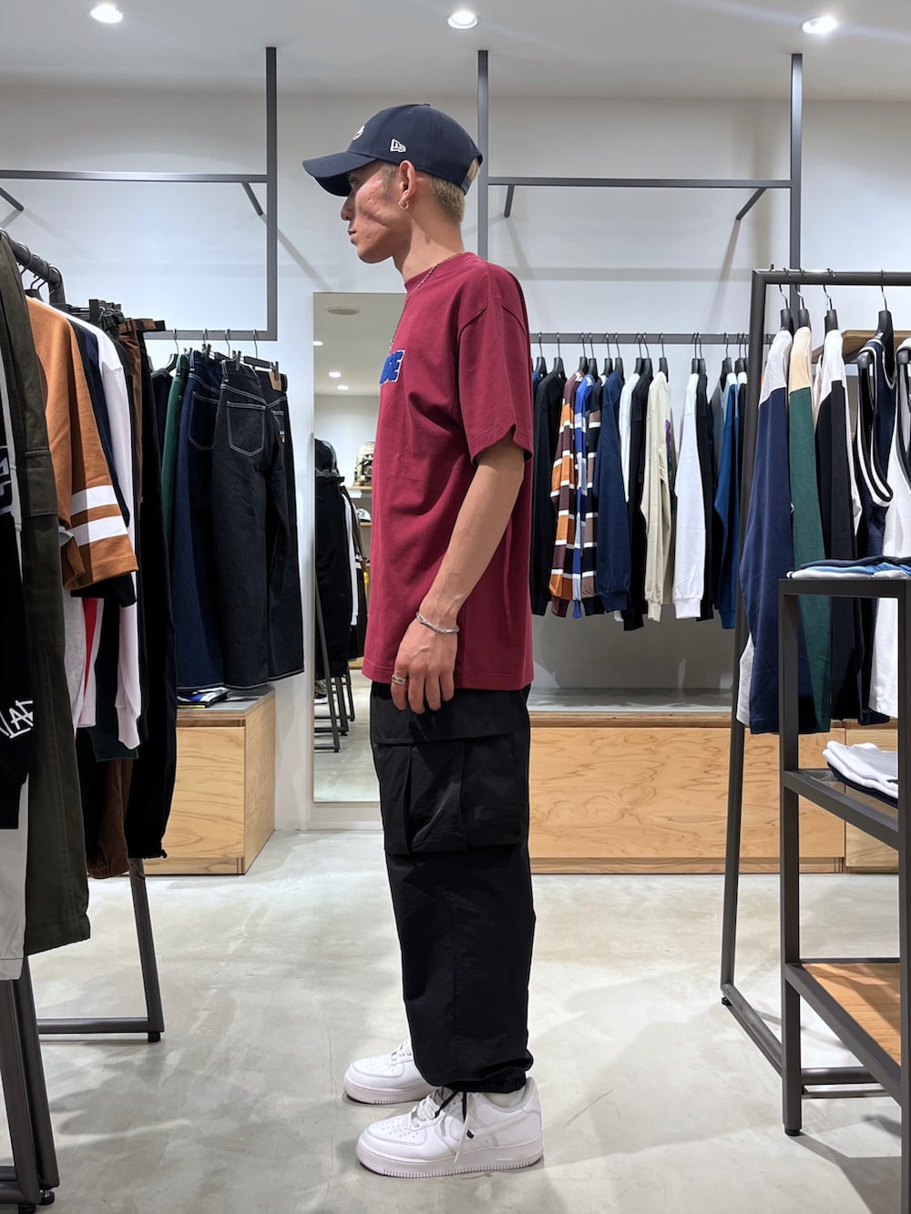 レッド系のTシャツ/カットソー、ブラック系のカーゴパンツ、ブルー系のキャップを着用したメンズの夏コーディネートの3枚目の写真