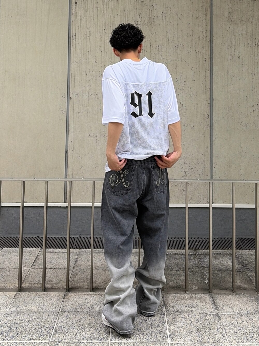 ホワイト系のTシャツ/カットソー、ブラック系のデニムパンツを着用したメンズの夏コーディネートの4枚目の写真