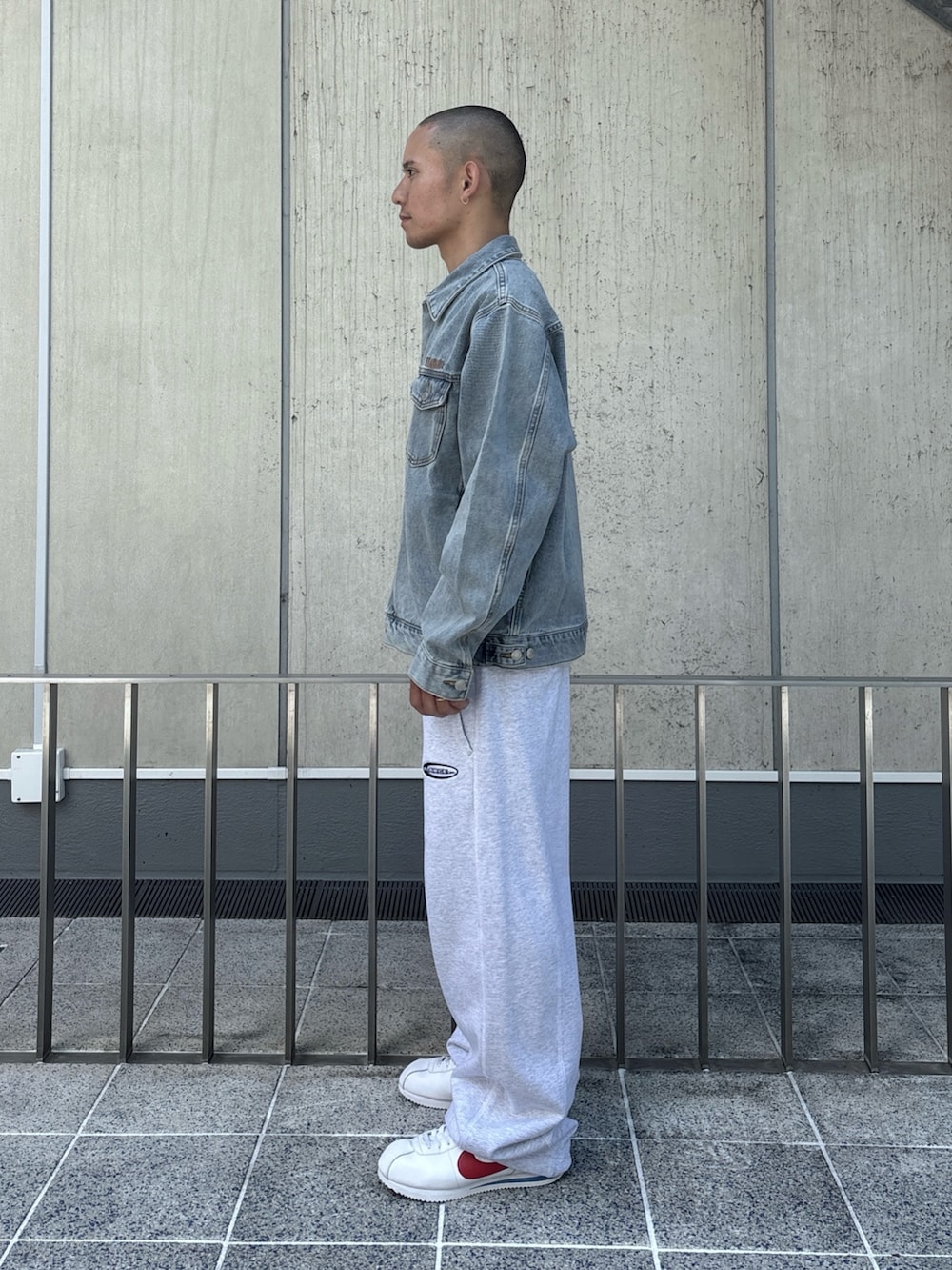 ブラック系のデニムジャケット、グレー系のスウェットパンツを着用したメンズの秋コーディネートの2枚目の写真