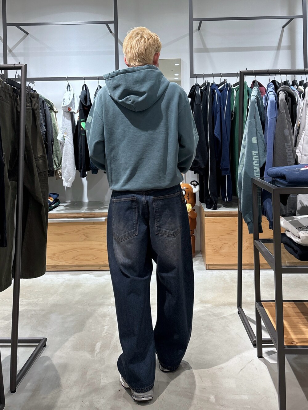 グリーン系のパーカー、ブルー系のデニムパンツを着用したメンズの冬コーディネートの4枚目の写真