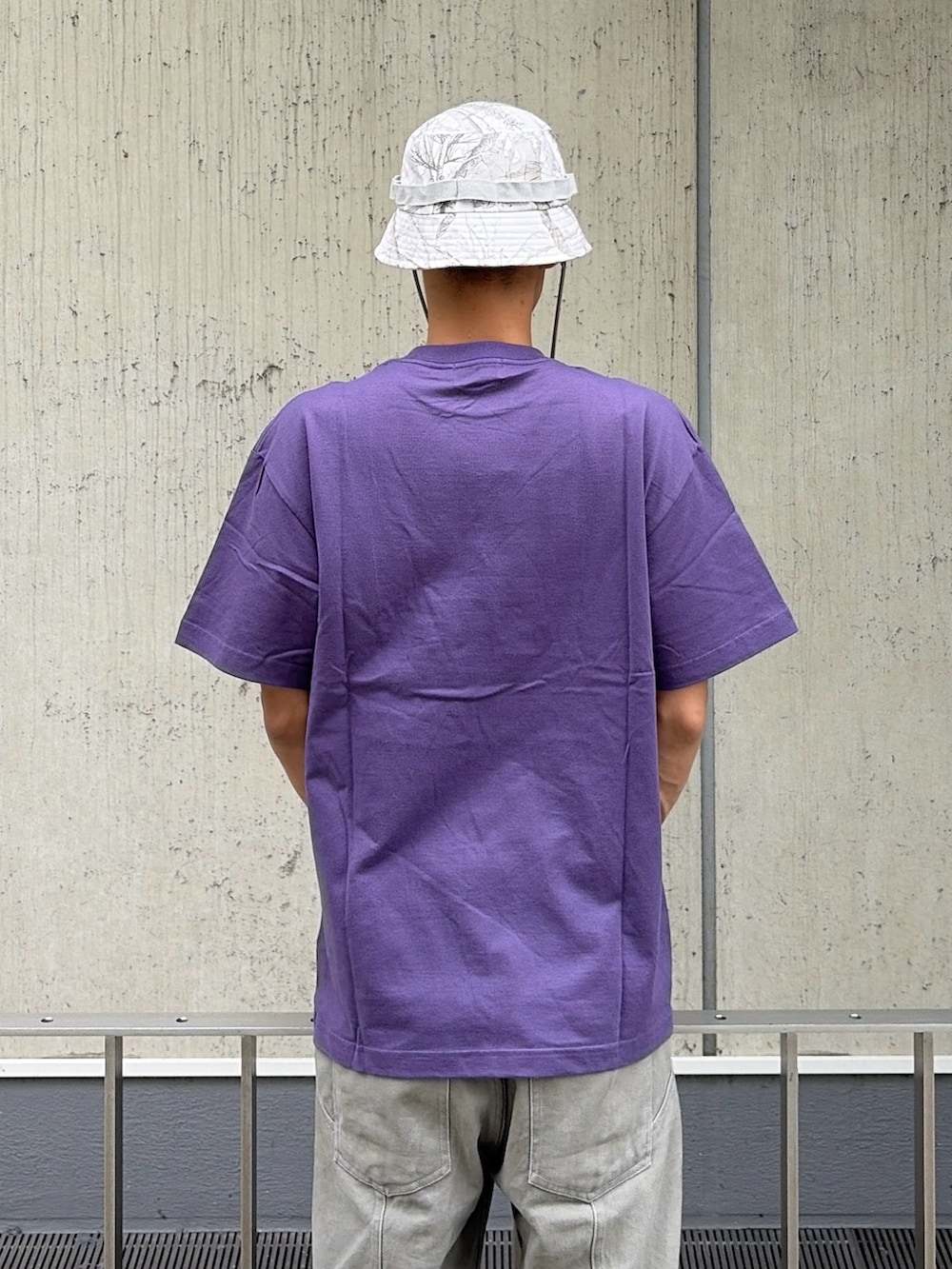 パープル系のTシャツ/カットソー、グレー系のその他パンツ、その他のハットを着用したメンズの夏コーディネートの6枚目の写真