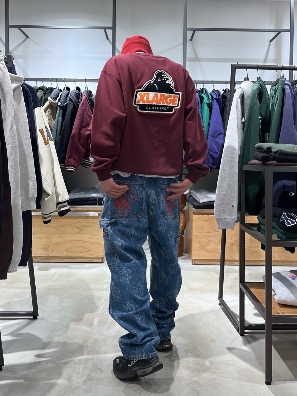 レッド系のスウェット、ブルー系のデニムパンツ、レッド系のニットキャップ/ビーニーを着用したメンズの冬コーディネートの5枚目の写真