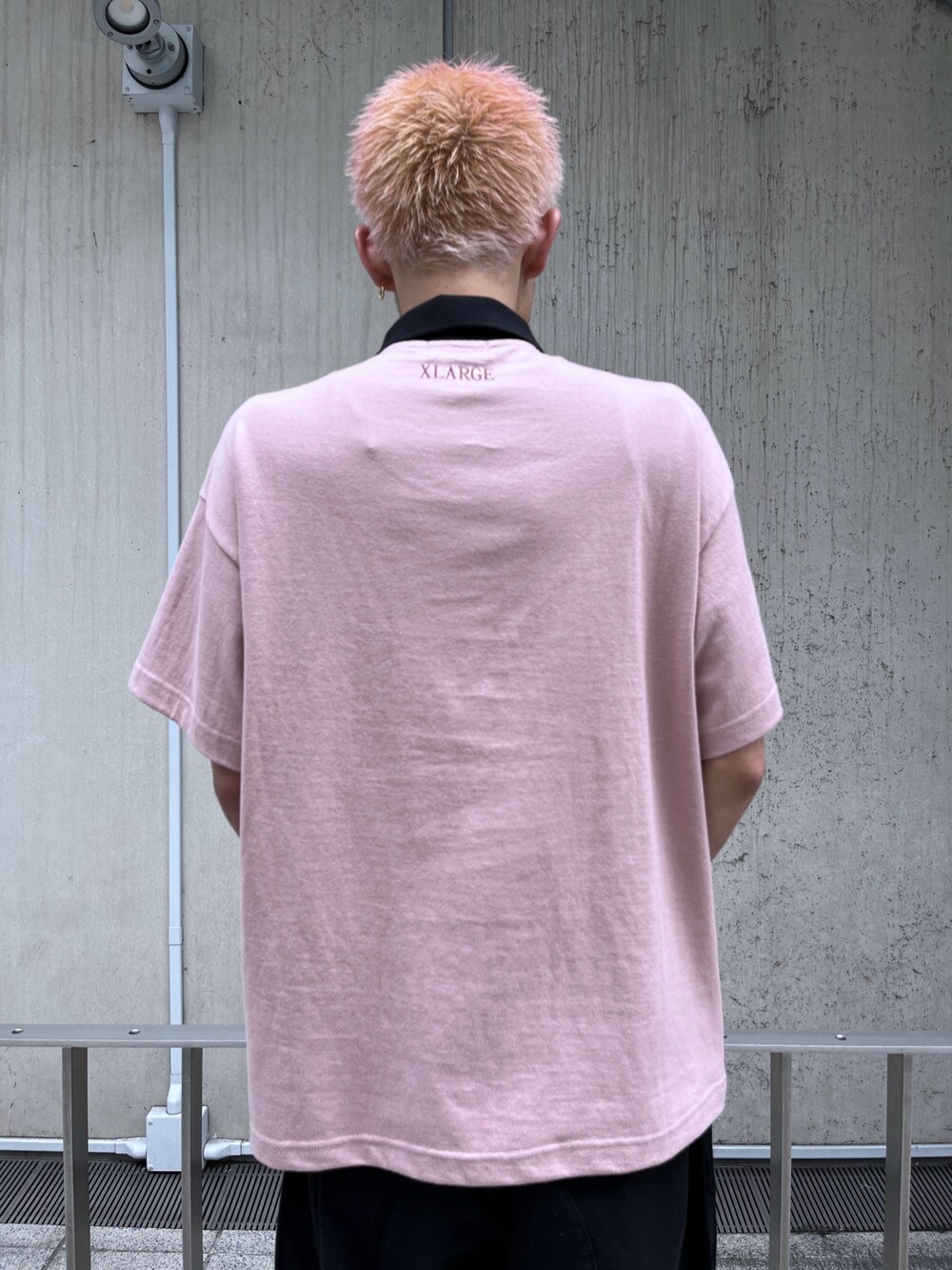 ピンク系のポロシャツ、ブラック系のカーゴパンツを着用したメンズの春コーディネートの5枚目の写真