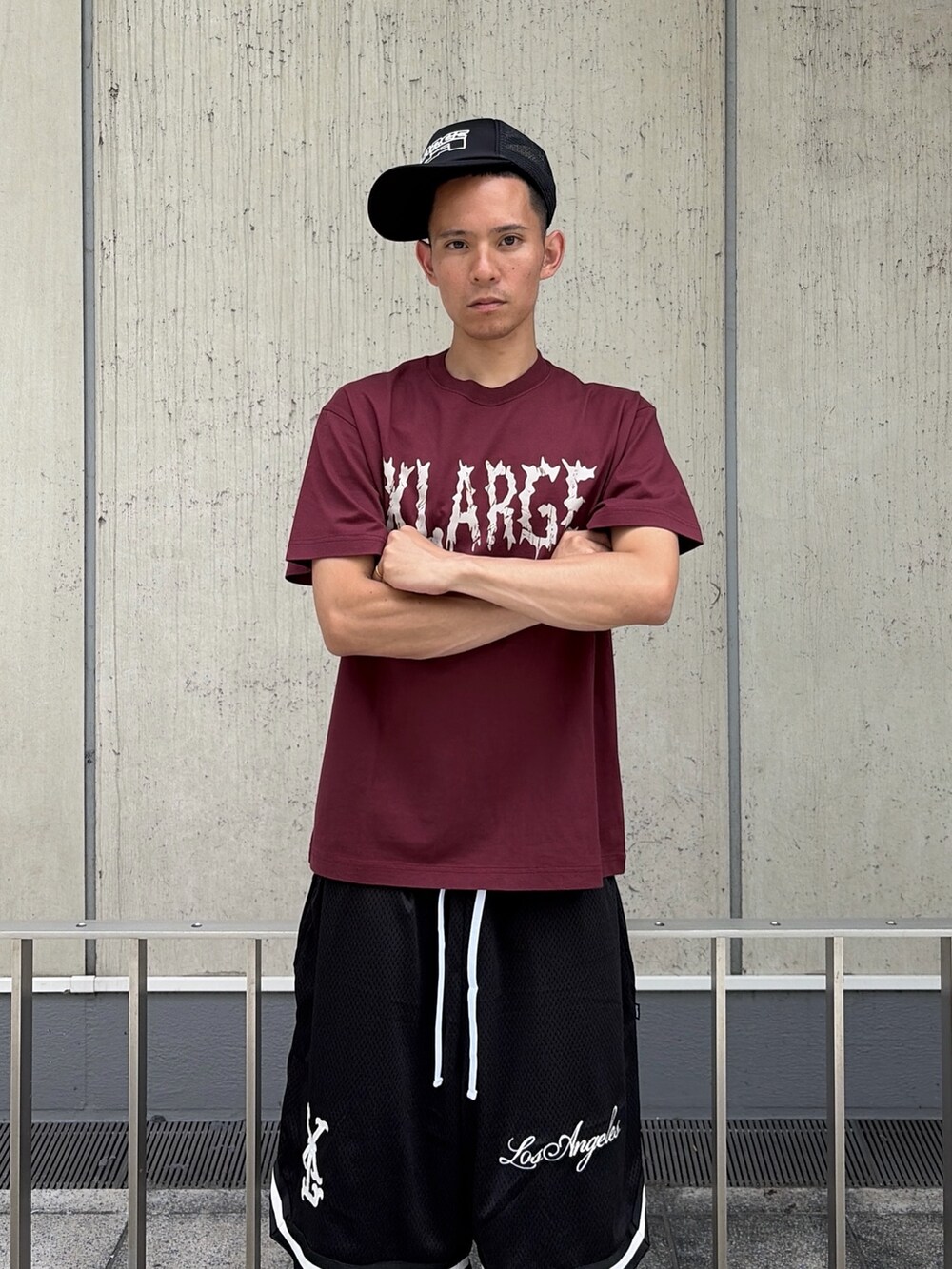 レッド系のTシャツ/カットソー、ブラック系のその他パンツ、ブラック系のキャップを着用したメンズの夏コーディネートの6枚目の写真