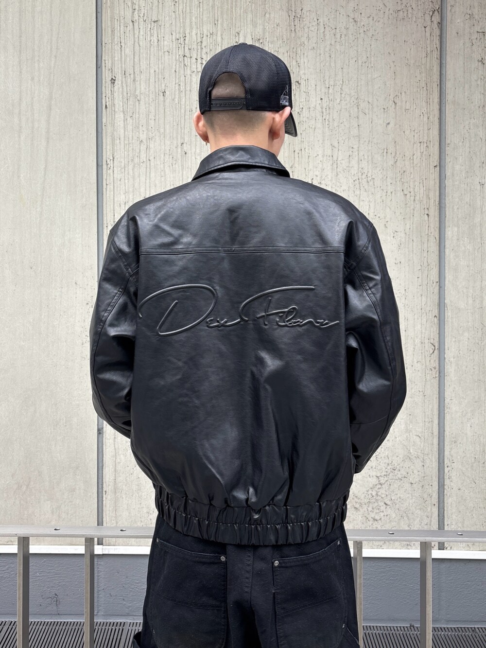 ブラック系のその他アウター、ブラウン系のその他パンツ、ブラック系のキャップを着用したメンズの冬コーディネートの7枚目の写真