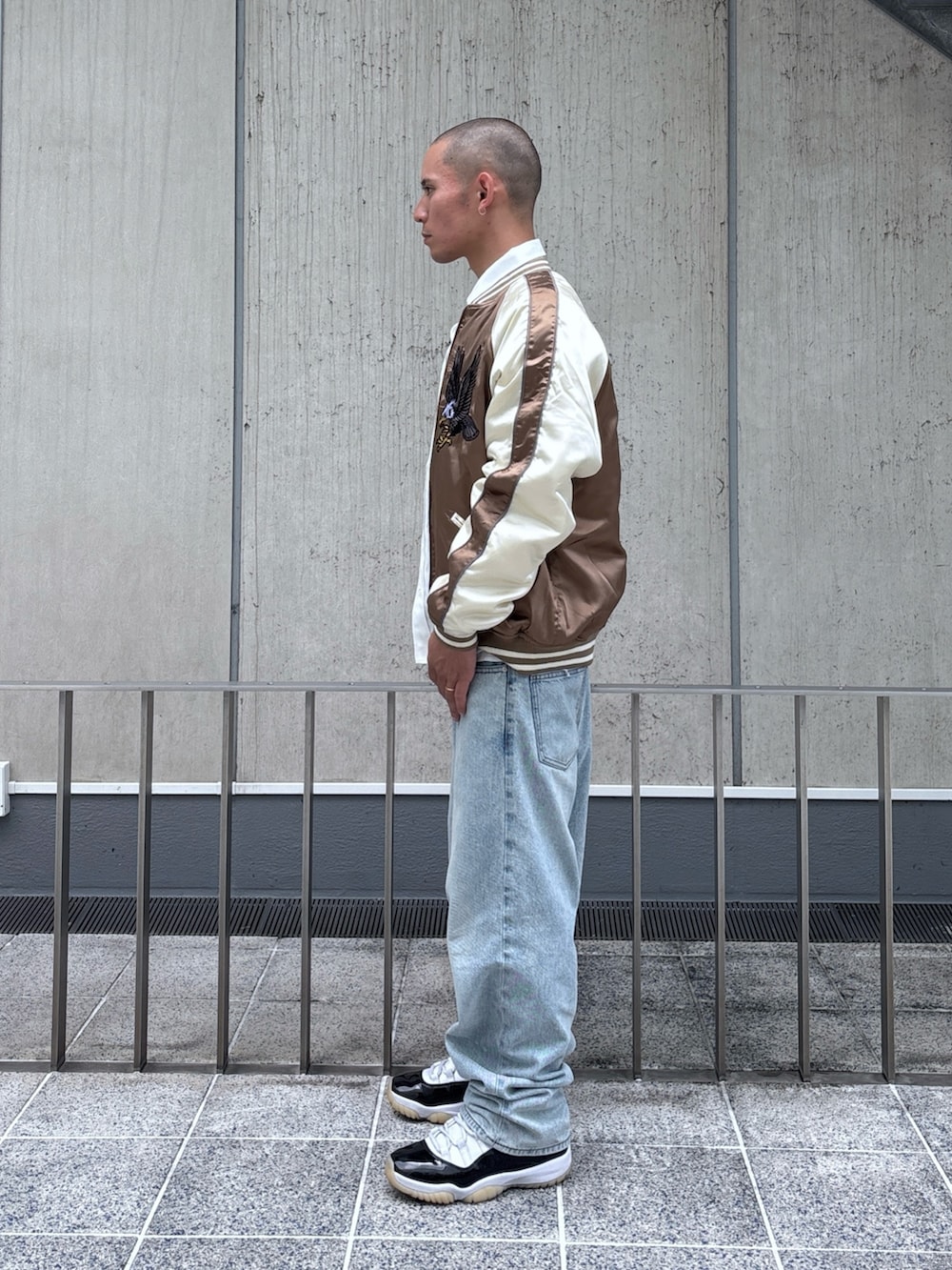 ブラウン系のスカジャン、ホワイト系のシャツ/ブラウス、ブラック系のデニムパンツを着用したメンズの秋コーディネートの2枚目の写真