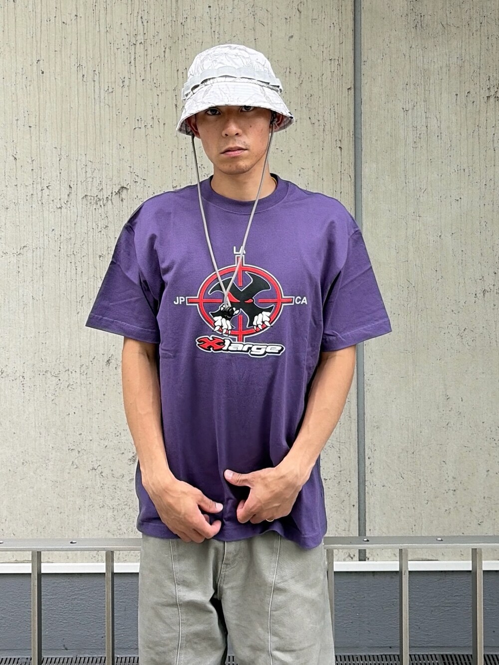 パープル系のTシャツ/カットソー、グレー系のその他パンツ、その他のハットを着用したメンズの夏コーディネートの5枚目の写真