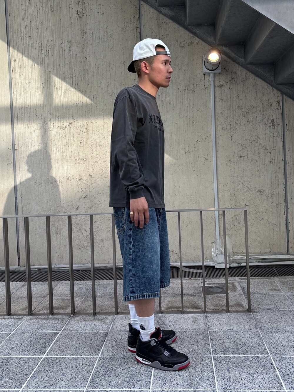 ブラック系のTシャツ/カットソー、ブルー系のその他パンツ、ホワイト系のキャップを着用したメンズの春コーディネートの3枚目の写真