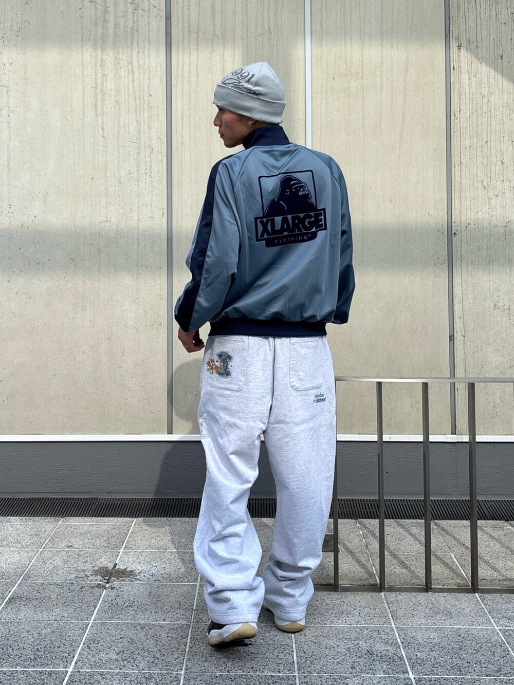 グレー系のスウェットパンツ、ブルー系のブルゾン、ブラック系のニットキャップ/ビーニーを着用したメンズの秋コーディネートの5枚目の写真