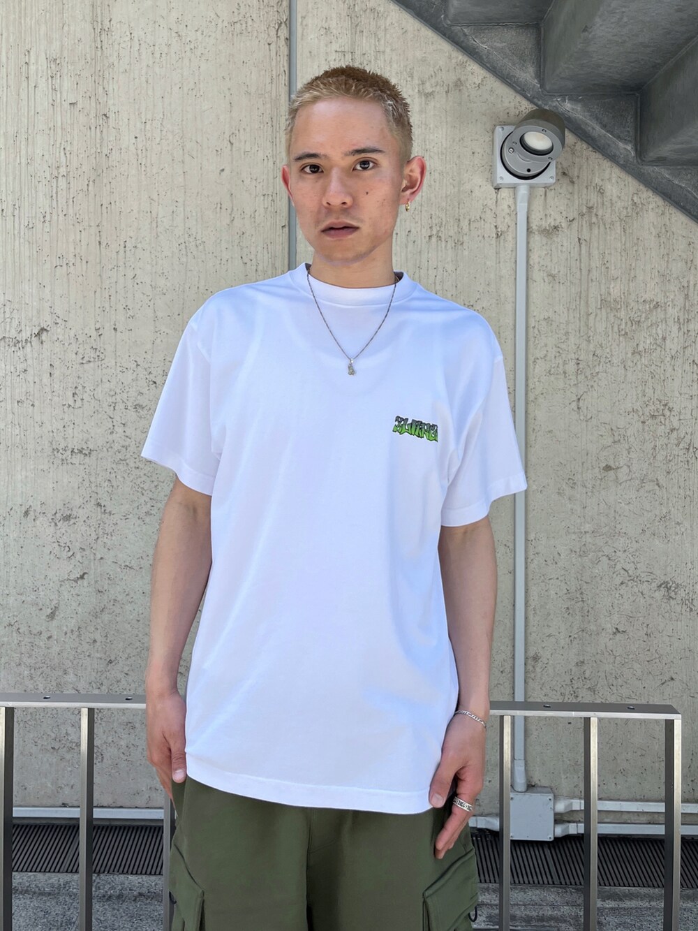 ホワイト系のTシャツ/カットソー、グリーン系のカーゴパンツを着用したメンズの春コーディネートの2枚目の写真