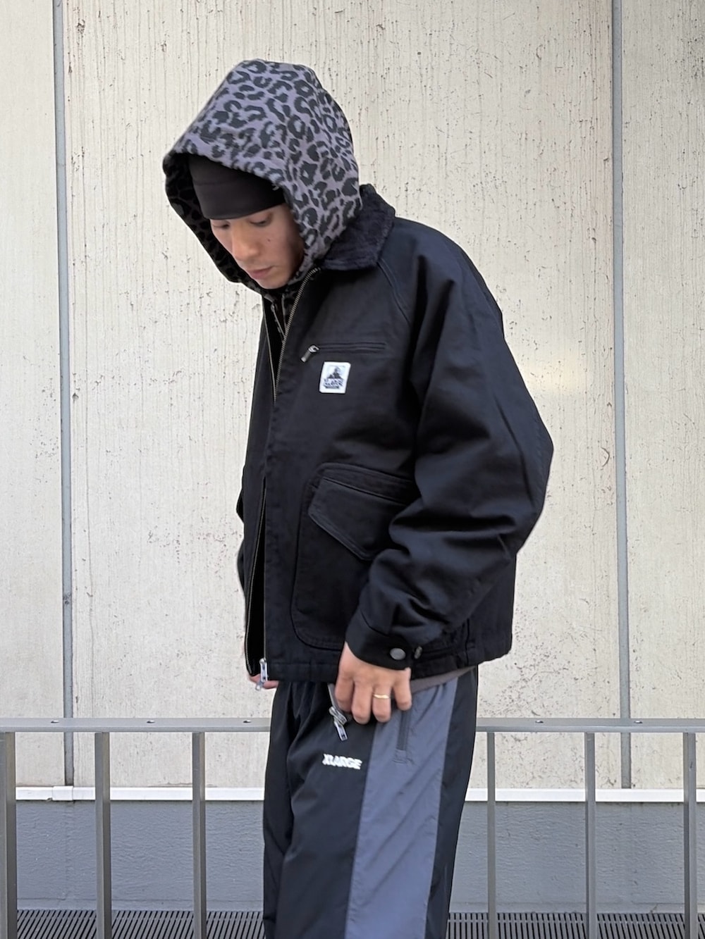 ホワイト系のパーカー、ブラック系のブルゾン、レッド系のその他パンツを着用したメンズの秋コーディネートの8枚目の写真