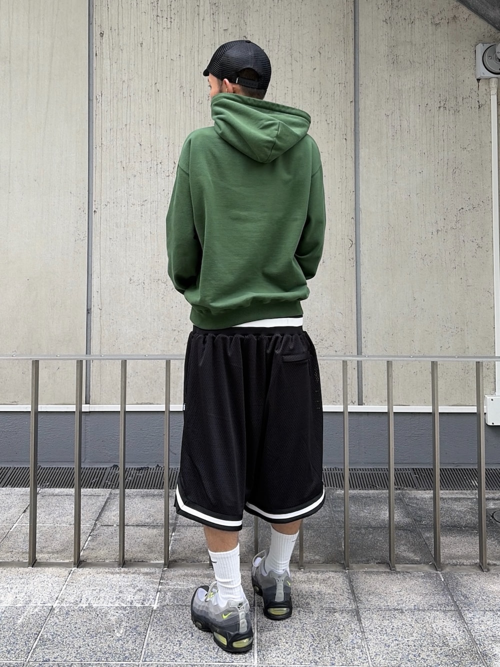グリーン系のパーカー、ブラック系のその他パンツ、ブラック系のキャップを着用したメンズの夏コーディネートの5枚目の写真