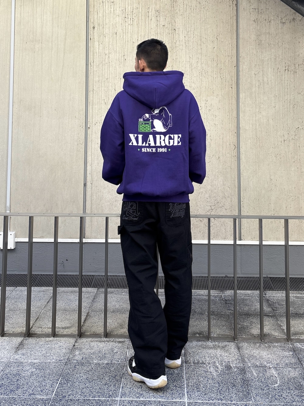 パープル系のパーカー、ブラック系のその他パンツを着用したメンズの冬コーディネートの4枚目の写真