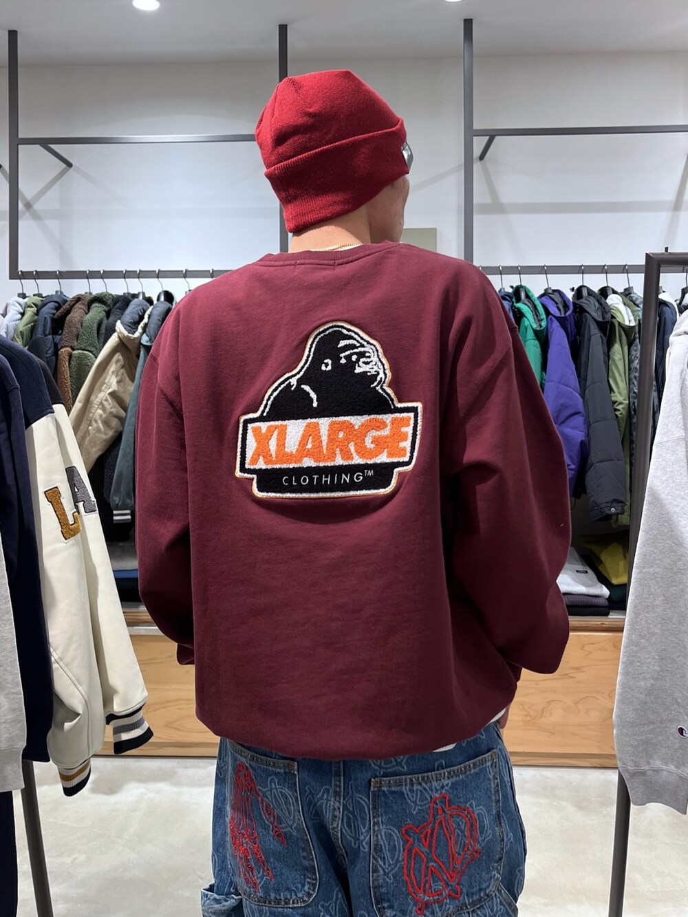 レッド系のスウェット、ブルー系のデニムパンツ、レッド系のニットキャップ/ビーニーを着用したメンズの冬コーディネートの8枚目の写真