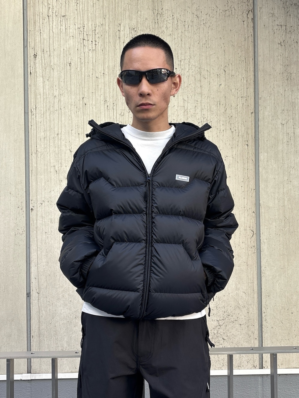 グリーン系のダウンジャケット/コート、ブラック系のその他パンツを着用したメンズの冬コーディネートの5枚目の写真