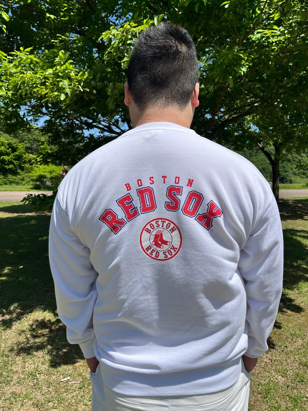 ホワイト系のスウェット、ホワイト系のパンツ、ブラック系のスニーカーを着用したメンズの春コーディネートの2枚目の写真