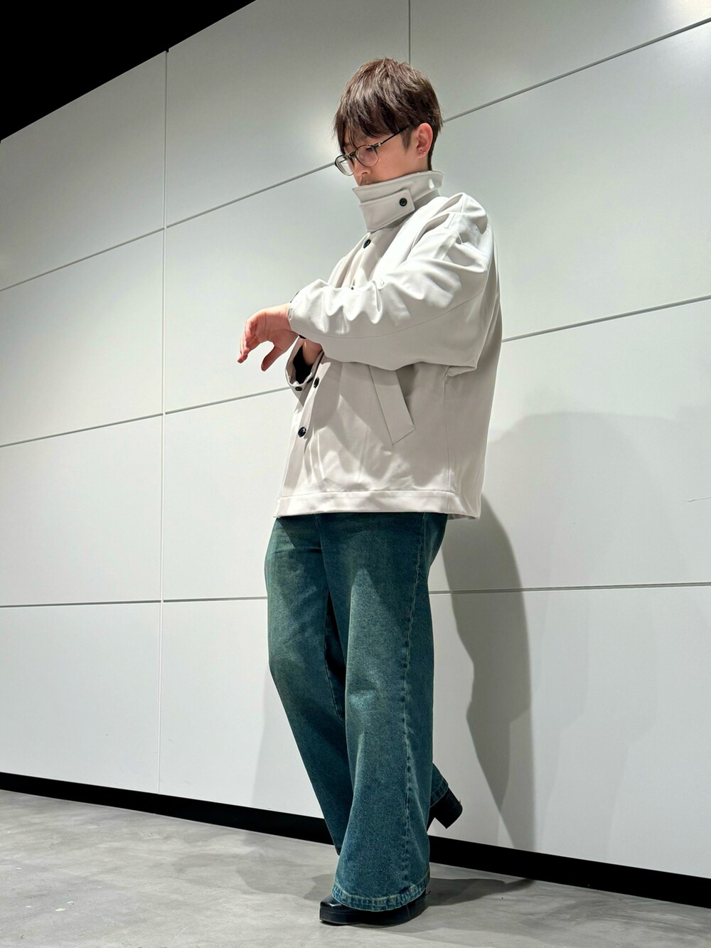 ブルー系のデニムパンツ、グレー系のブルゾン、ブラック系のブーツを着用したメンズの春コーディネートの2枚目の写真