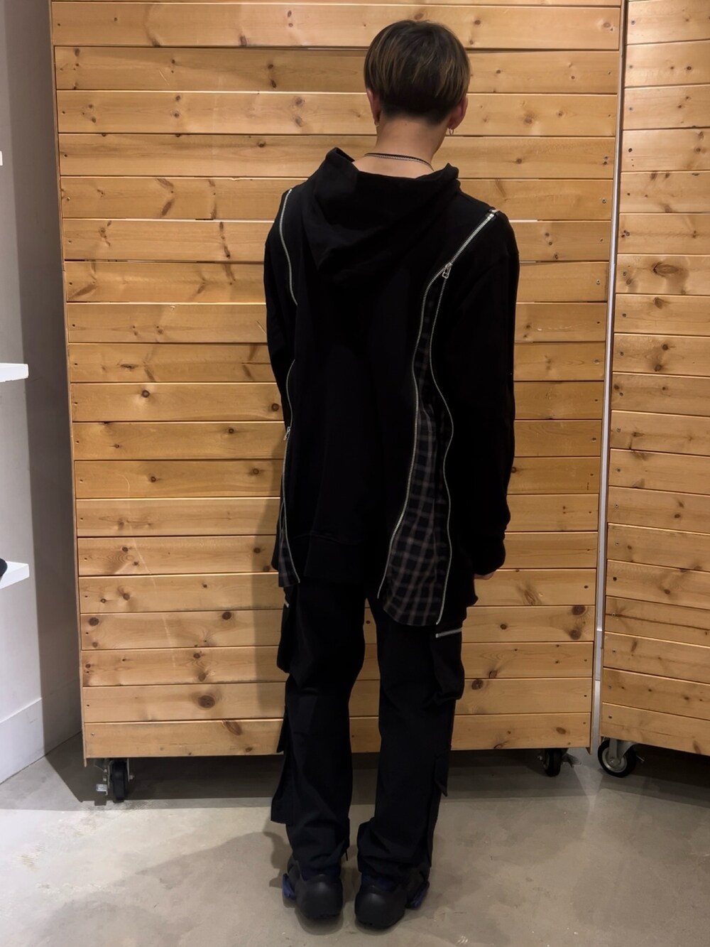 ブラック系のカーゴパンツ、パープル系のスニーカー、ブラック系のパーカーを着用したメンズの春コーディネートの2枚目の写真