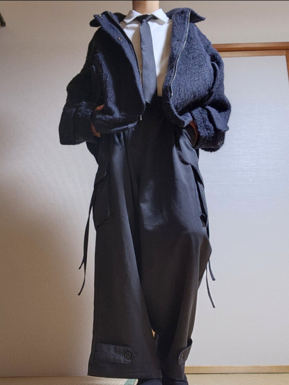 グレー系のカーゴパンツ、ブラック系のブルゾン、ブラック系のネクタイを着用したメンズの秋コーディネートの2枚目の写真