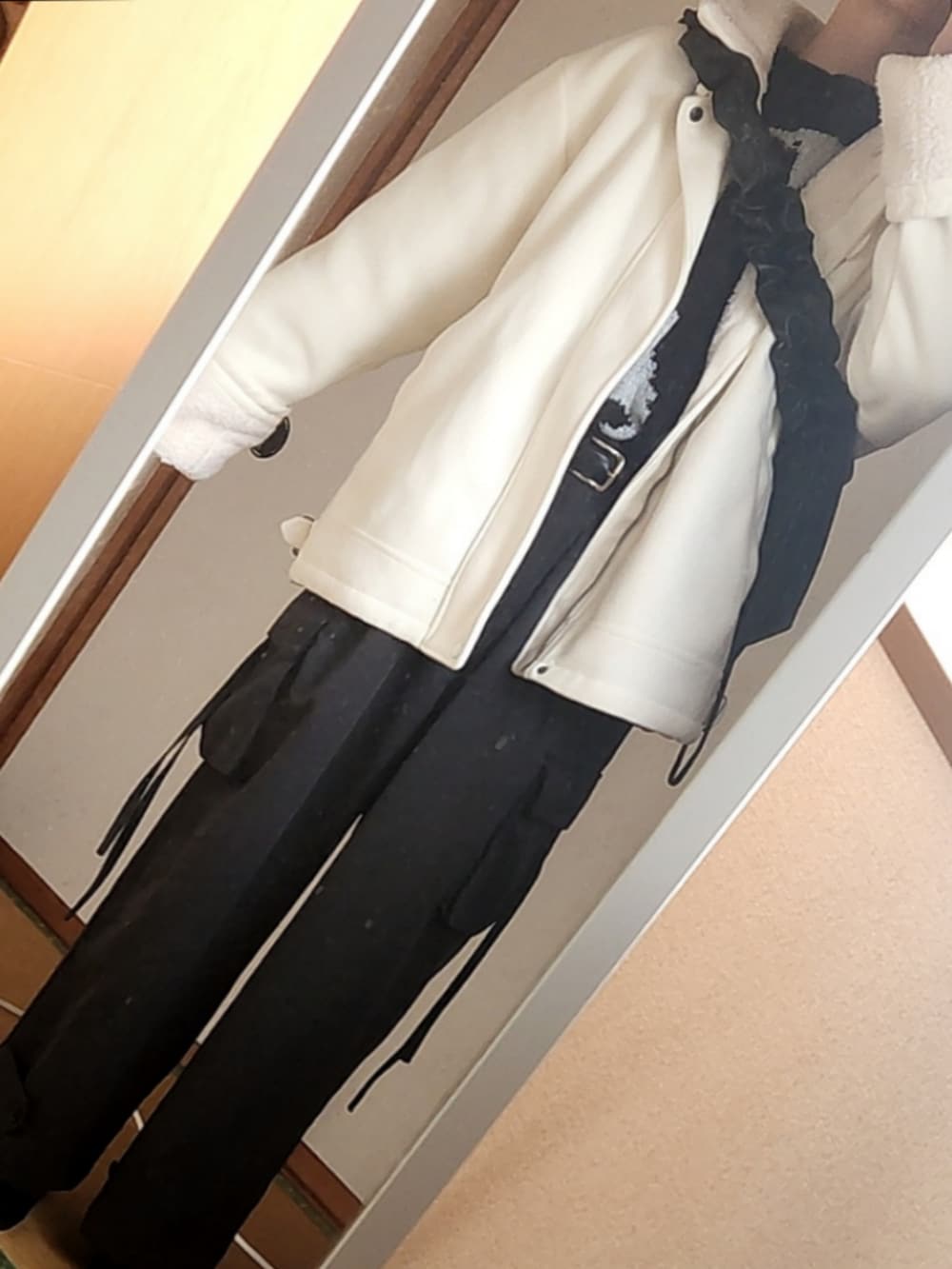 グレー系のカーゴパンツ、ホワイト系のムートンコート、ブラック系のショルダーバッグを着用したメンズの冬コーディネートの2枚目の写真