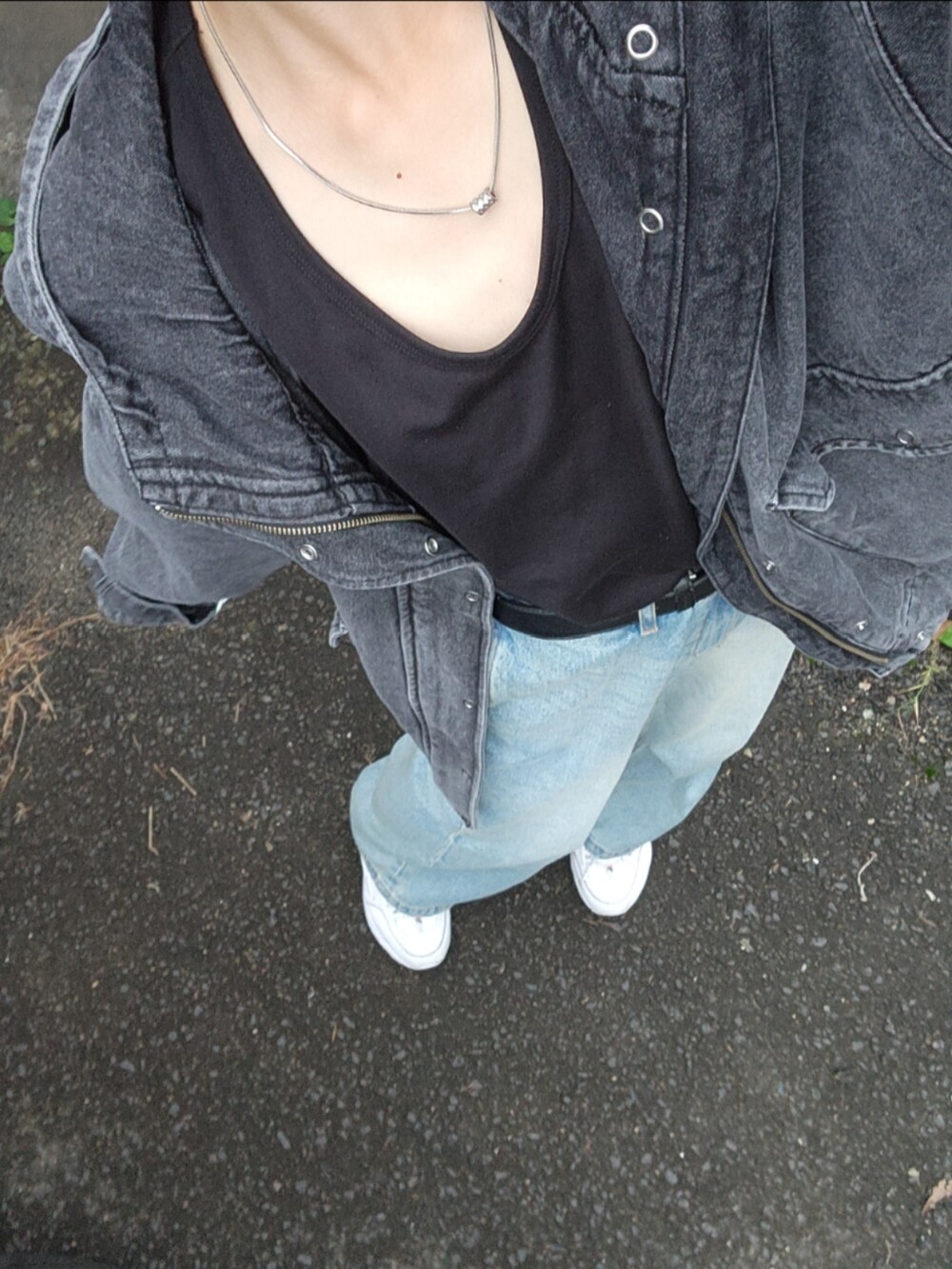 ブラック系のタンクトップ、ブラック系のマウンテンパーカー、ベージュ系のデニムパンツを着用したメンズの秋コーディネートの2枚目の写真