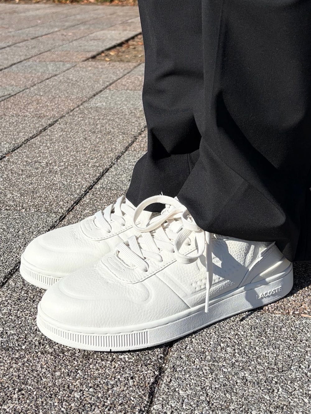 ブラック系のデニムジャケット、ホワイト系のパーカー、ホワイト系のスニーカーを着用したレディースの冬コーディネートの4枚目の写真