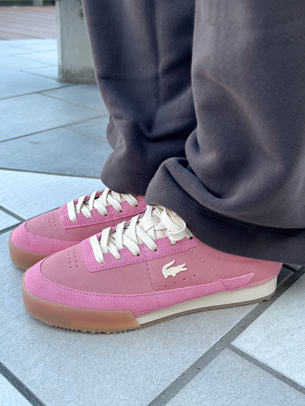 ブラック系のショルダーバッグ、ピンク系のスニーカー、ブラウン系のスウェットを着用したレディースの秋コーディネートの5枚目の写真