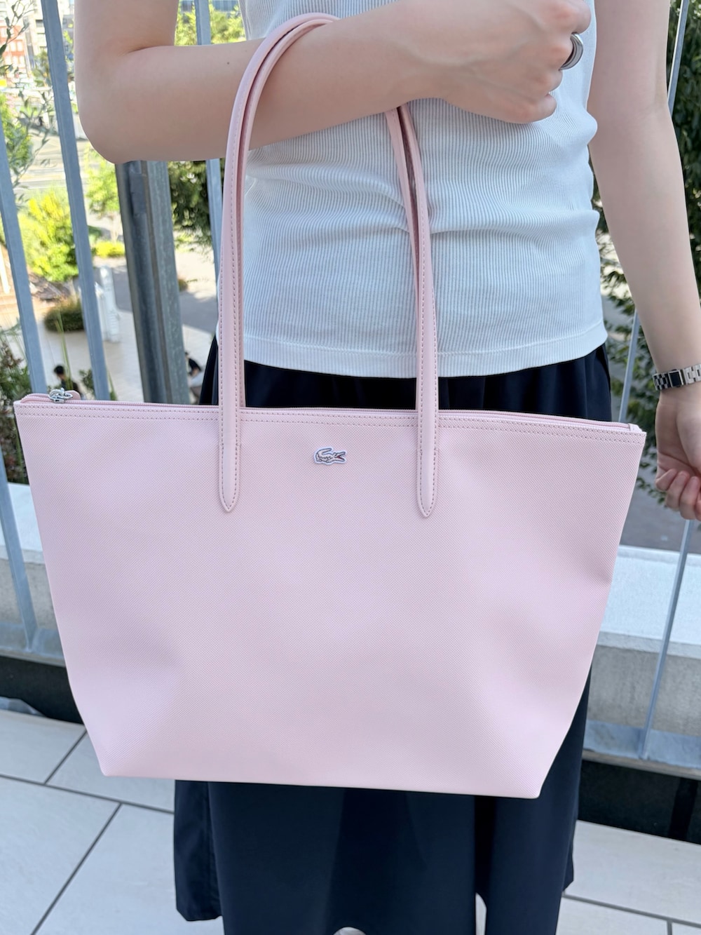 ホワイト系のポロシャツ、ブルー系のスカート、ピンク系のトートバッグを着用したレディースの夏コーディネートの4枚目の写真