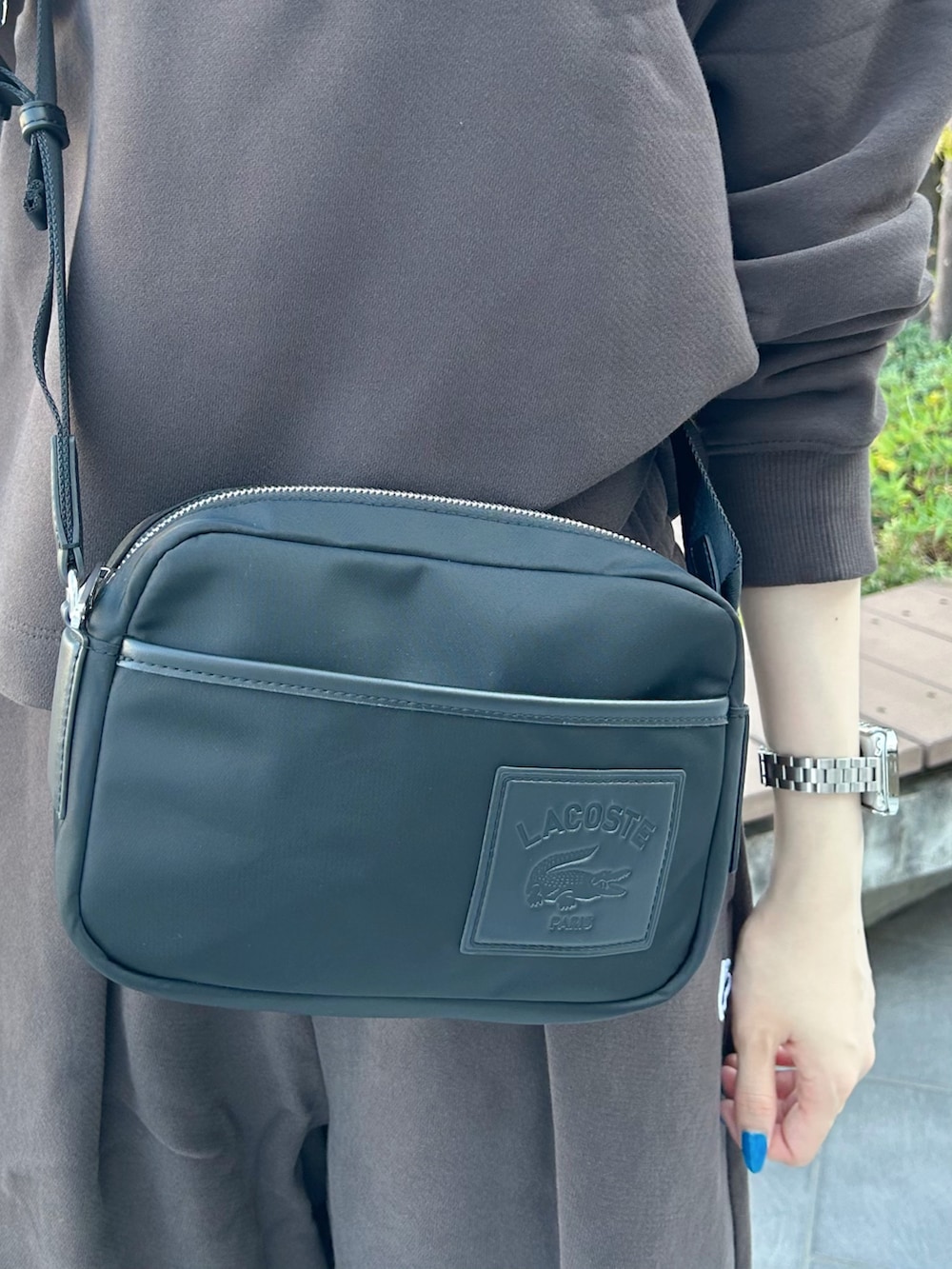 ブラック系のショルダーバッグ、ピンク系のスニーカー、ブラウン系のスウェットを着用したレディースの秋コーディネートの4枚目の写真