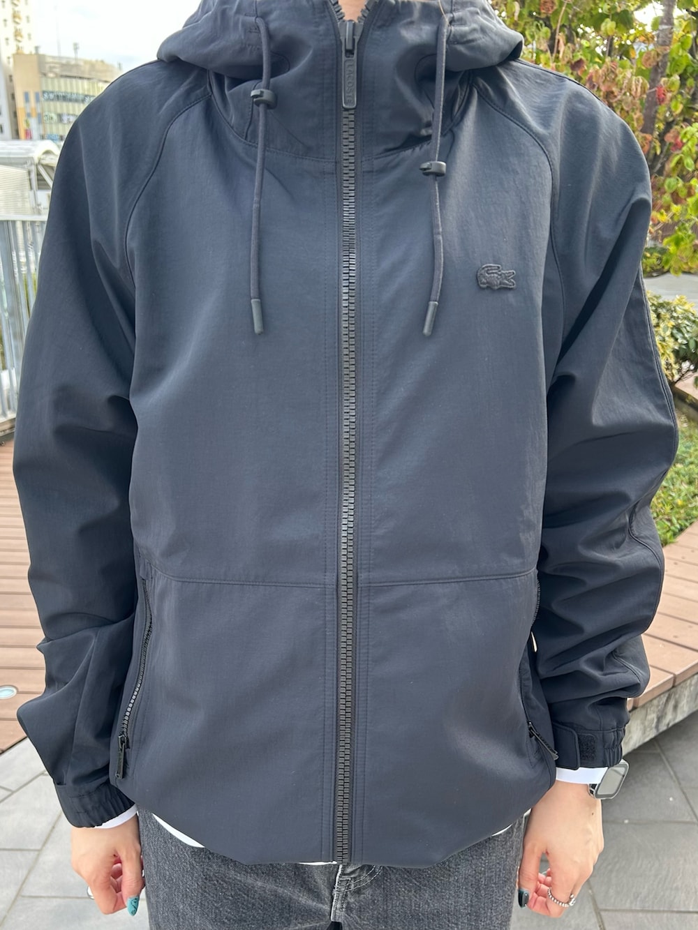 ブラック系のブルゾン、ブラック系のデニムパンツ、グレー系のスニーカーを着用したレディースの秋コーディネートの3枚目の写真