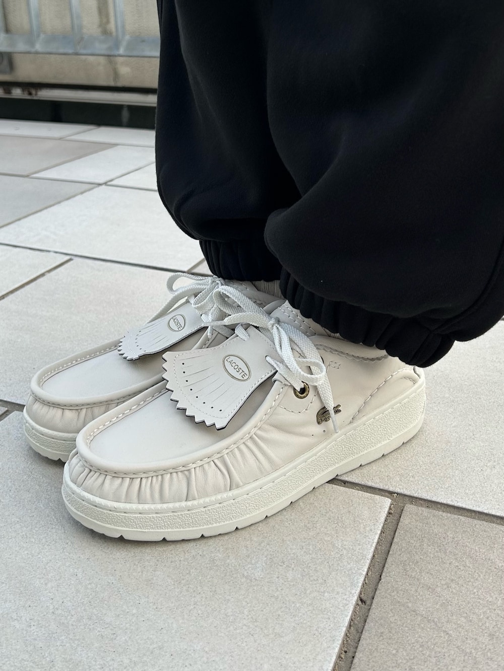 ブラック系のカーディガン/ボレロ、ベージュ系のトートバッグ、ブラック系のスウェットパンツを着用したレディースの秋コーディネートの5枚目の写真