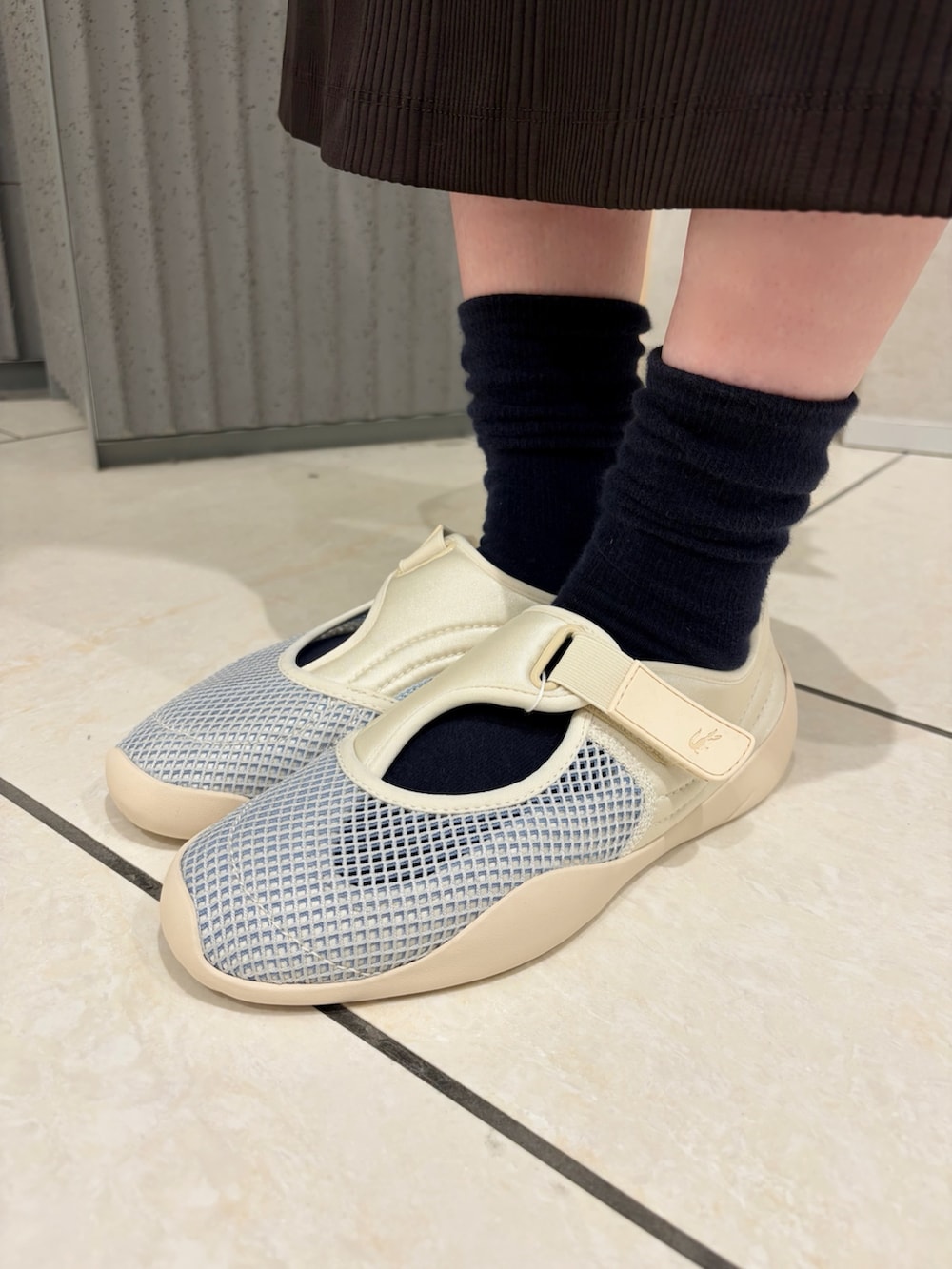 ホワイト系のスニーカー、グリーン系のカーディガン/ボレロ、ブラウン系のワンピースを着用したレディースの夏コーディネートの5枚目の写真
