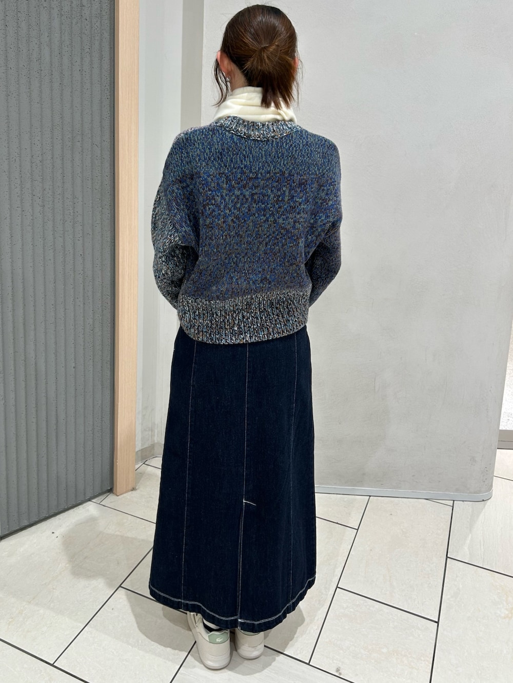 その他のニット/セーター、ブルー系のデニムスカート、ブラック系のトートバッグを着用したレディースの冬コーディネートの2枚目の写真