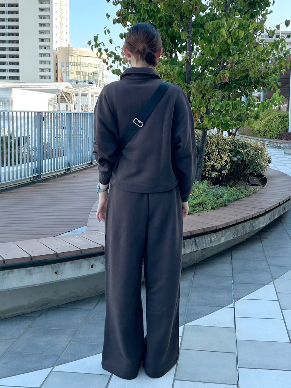 ブラック系のショルダーバッグ、ピンク系のスニーカー、ブラウン系のスウェットを着用したレディースの秋コーディネートの3枚目の写真