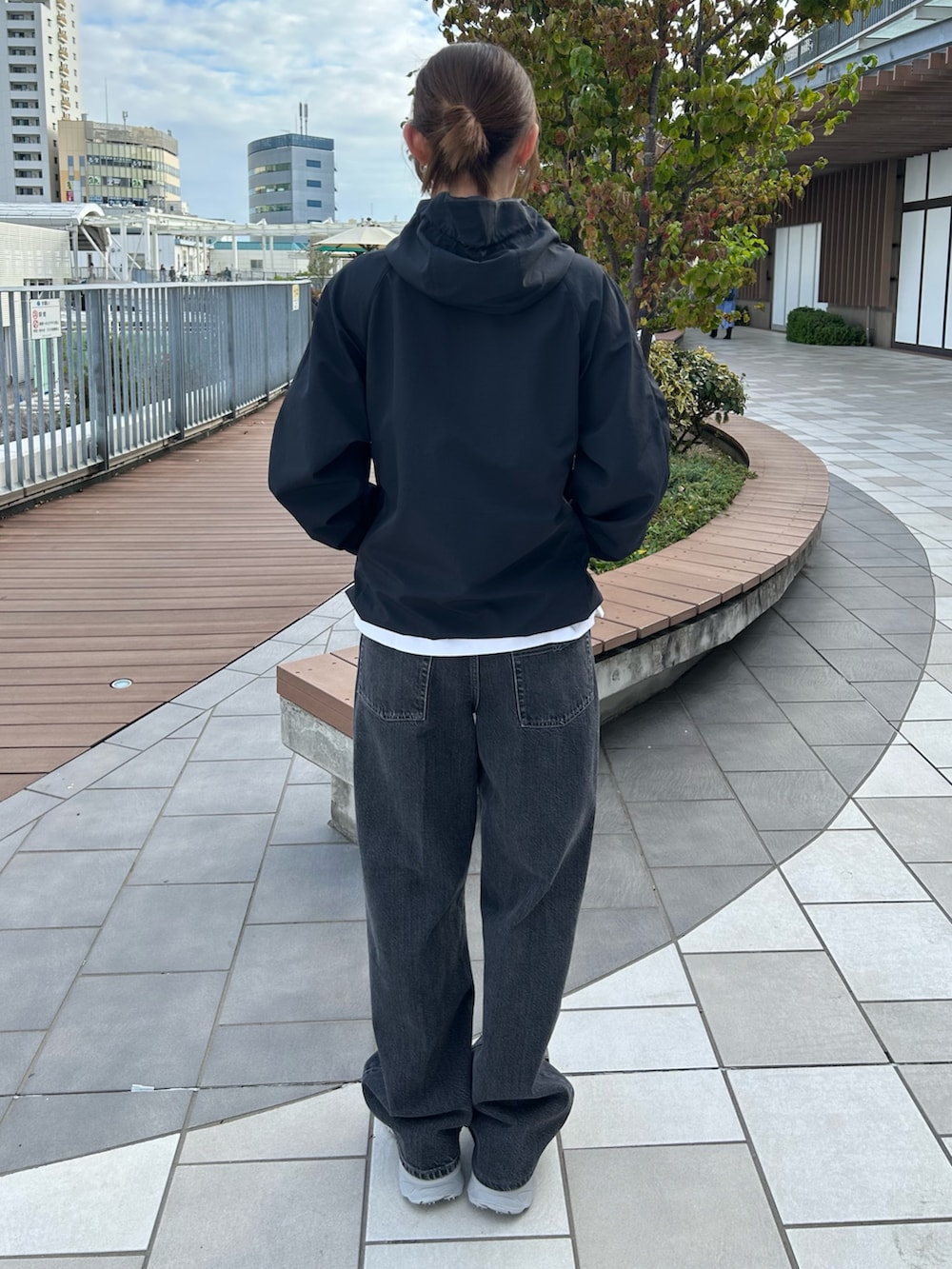 ブラック系のブルゾン、ブラック系のデニムパンツ、グレー系のスニーカーを着用したレディースの秋コーディネートの2枚目の写真