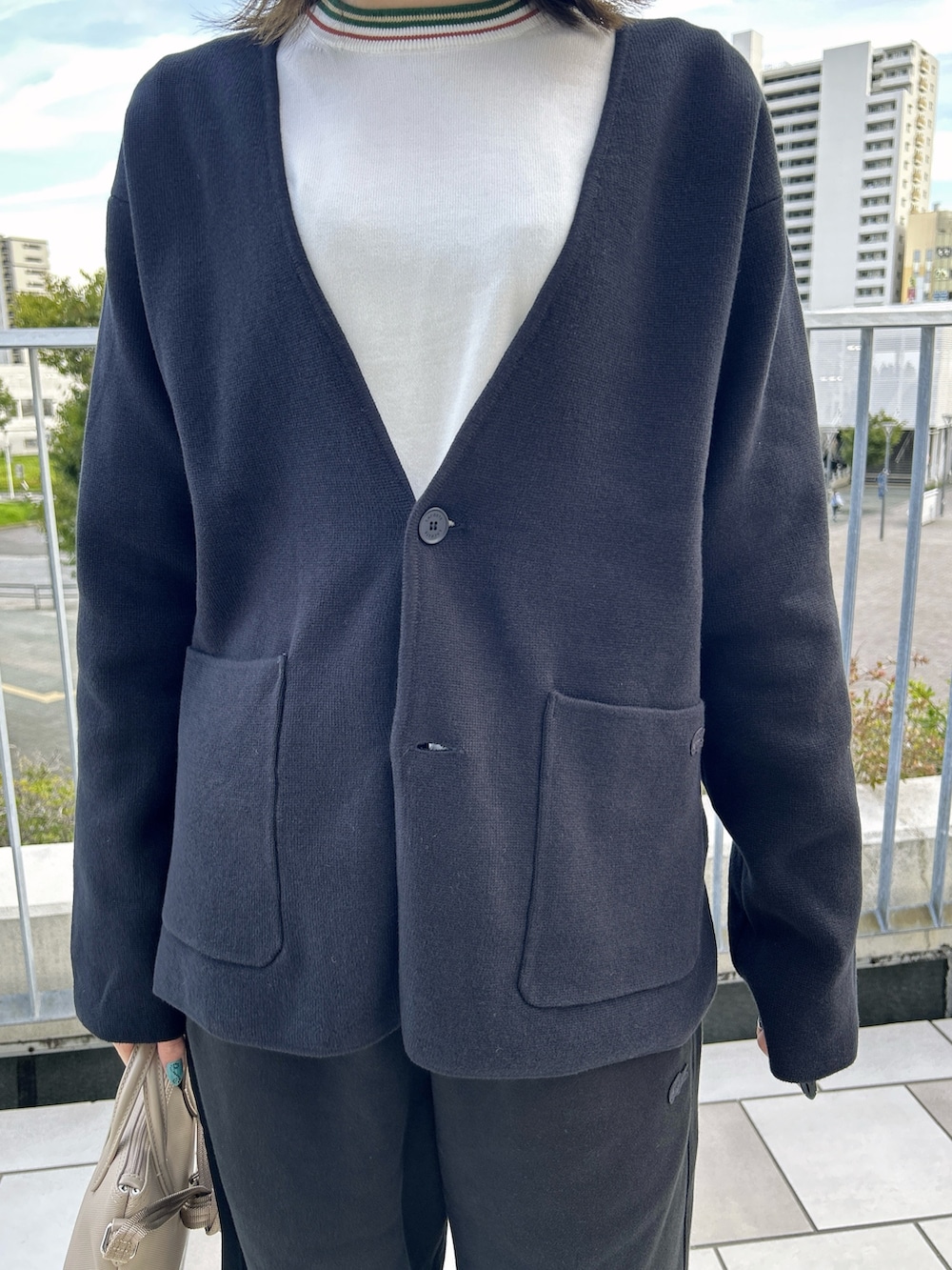 ブラック系のカーディガン/ボレロ、ベージュ系のトートバッグ、ブラック系のスウェットパンツを着用したレディースの秋コーディネートの3枚目の写真