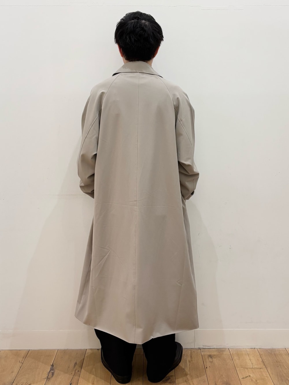 グレー系のTシャツ/カットソー、ブラック系のその他パンツ、ベージュ系のステンカラーコートを着用したメンズの冬コーディネートの3枚目の写真