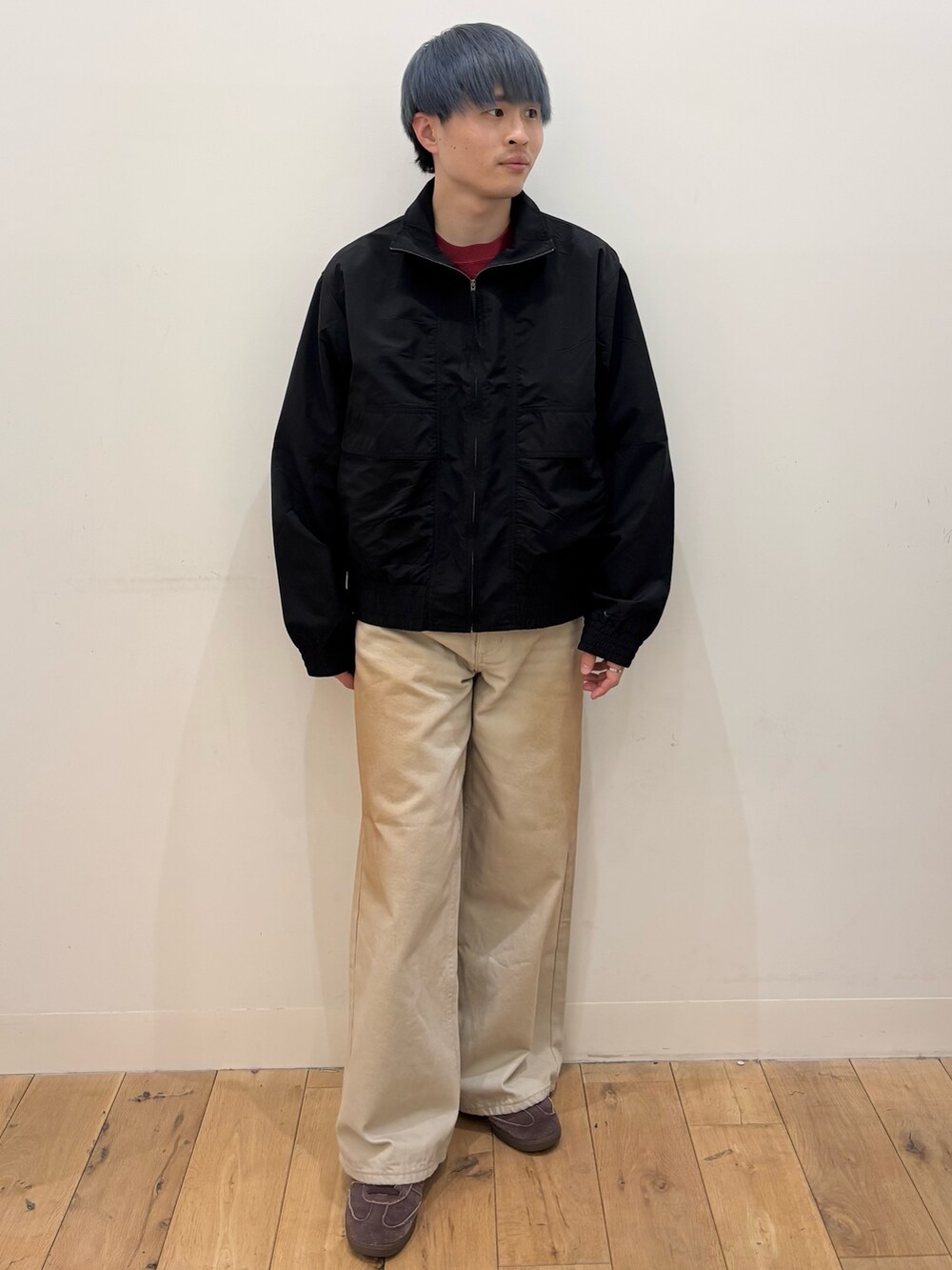 ブラック系のブルゾン、レッド系のスウェット、グリーン系のデニムパンツを着用したメンズの春コーディネートの2枚目の写真