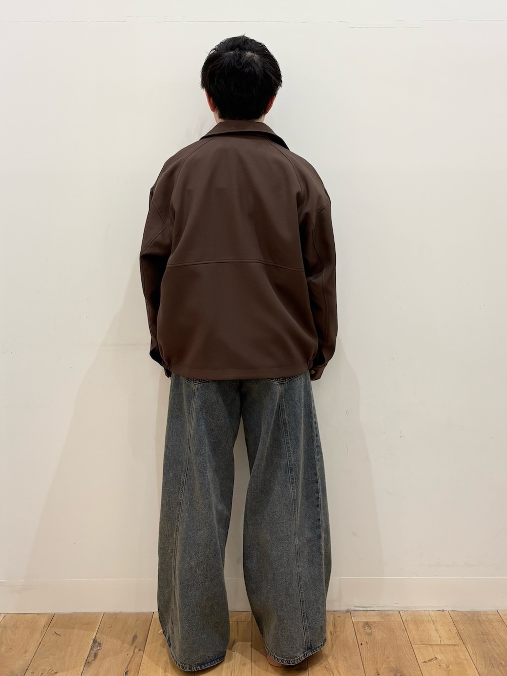 グレー系のスウェット、ブラウン系のブルゾン、ブルー系のデニムパンツを着用したメンズの冬コーディネートの3枚目の写真